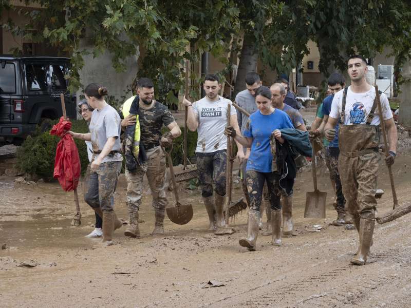 Varias personas colaboran en la limpieza de una calle afectada. EFElvaro del Olmo