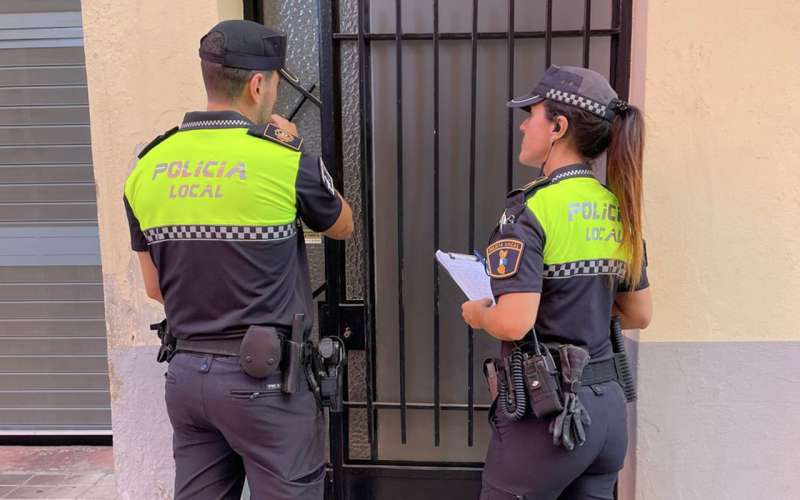 Dos agentes de Polica Local revisan un patio. EPDA