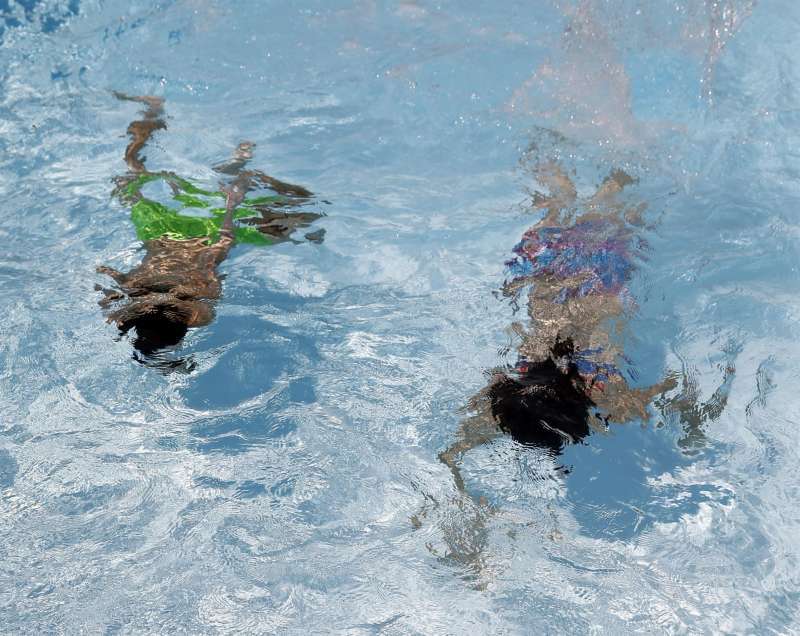 Dos personas se refrescan en el interior de una piscina