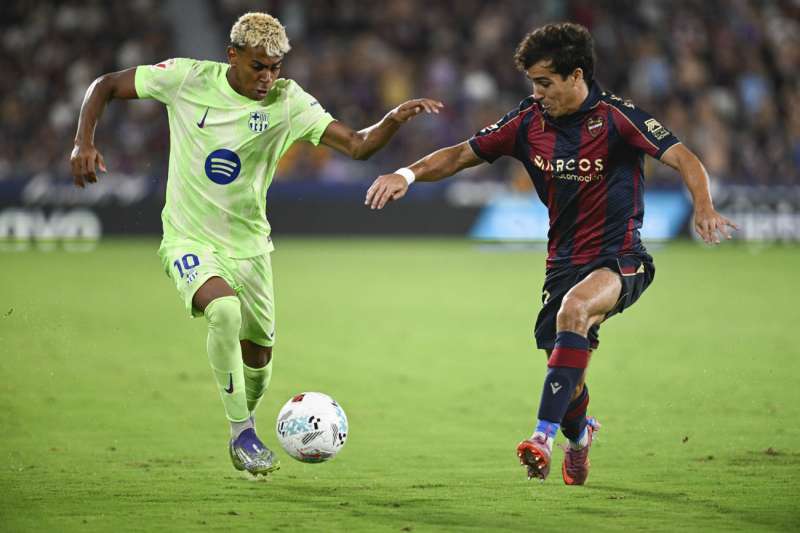 El delantero del Barcelona Lamine Yamal (i) trata de escapar de Manu Snchez, del Levante, durante el partido de LaLiga de ftbol que Levante UD y FC Barcelona disputaron en el estadio Ciutat de Valencia. EFEAndreu Esteban