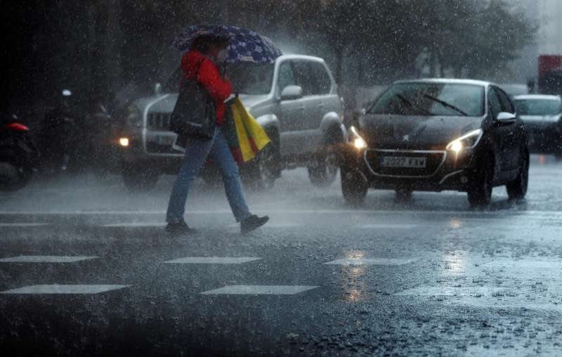 Una persona camina bajo una intensa lluvia. EFE/Kai Försterling/Archivo
