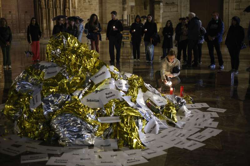 Varias personas colocan velas en un altar improvisado en el acto de denuncia y homenaje a las vctimas de la dana. EFE Biel Alio