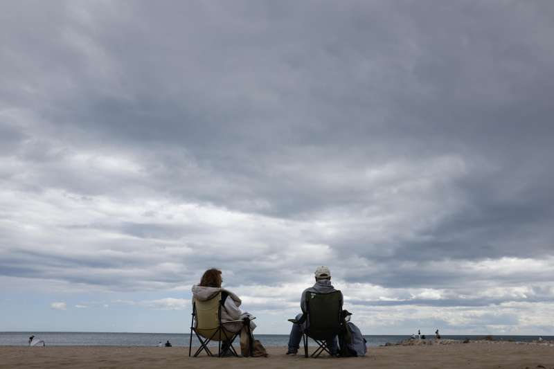 Una pareja conversa en una playa de Valencia en una imagen de archivo. EFE Ana Escobar Archivo

