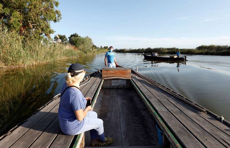  Un barquero de El Palmar recibe a turistas que vistan el parque natural de La Albufera. /EFE
