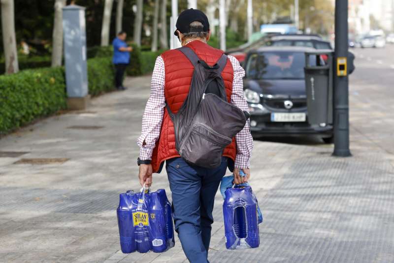 Un hombre carga con varias botellas de agua durante la maana de este mircoles en Valencia. EFEAna Escobar