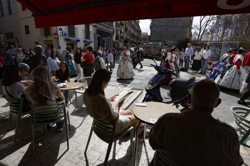 Varias personas en una terraza de Val�ncia tomando algo fresco y viendo pasar las comisiones falleras. EFEManuel Bruque