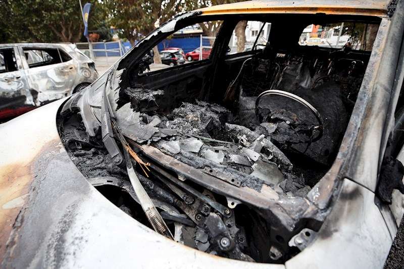 Un coche quemado en una calle. /EFE