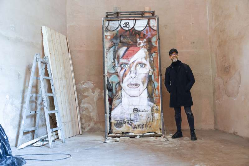 El artista Jesus ArrÃºe posa con el el grafiti de David Bowie. /EFE