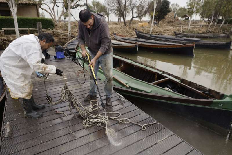  Varias personas limpian las barcas y utensilios en el puerto de la Albufera en Catarroja, este lunes. EFE Kai Forsterling