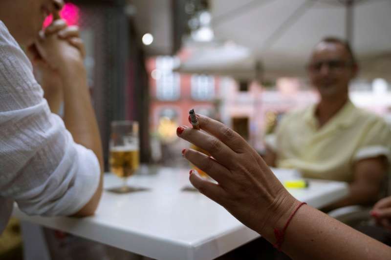 Una mujer sostiene un cigarrillo en la terraza de en un bar. EFE/Miguel Barreto/Archivo
