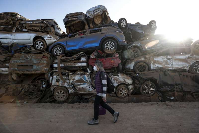 Una mujer ante decenas de coches depositados en un descampado en la localidad de Paiporta.. EFEManuel Bruque