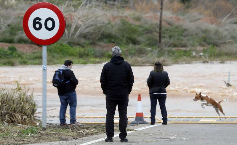 Varias personas contemplan la corriente de agua que lleva el barranco del Carraixet a consecuencia de un temporal en enero de 2017. EFEKai Frsterling
