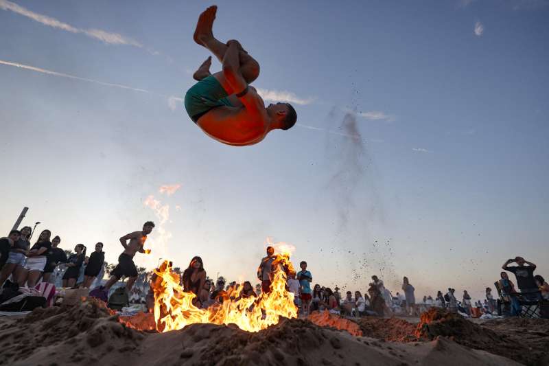 Un joven salta una hoguera en una playa de Valencia en la tradicional noche de San Juan. EFEManuel Bruque
