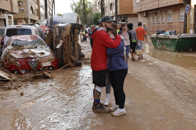 Dos personas se abrazan en la localidad de Paiporta, Valencia, este jueves. EFE Biel Alio