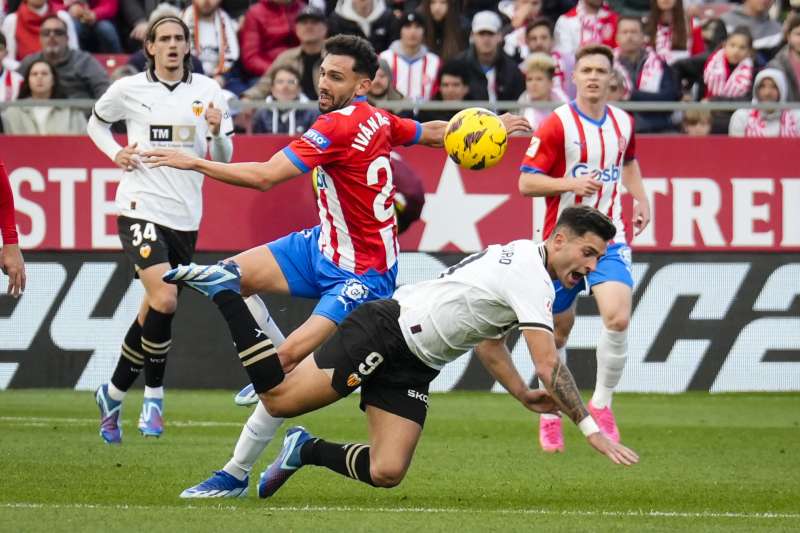 El centrocampista del Girona Iván Martín (ci), disputa una posesión ante Hugo Duro, delantero del Valencia durante el partido correspondiente a la jornada 15 de LaLiga en el estadio municipal de Montilivi. EFE/ David Borrat