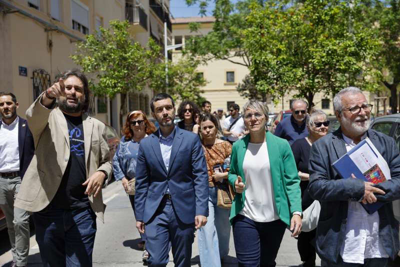 El ministro de Derechos Sociales, Consumo y Agenda 2030, Pablo Bustinduy (2 i), y la portavoz municipal de Comproms, Papi Robles, durante su recorrido por el barrio del Cabanyal junto a vecinos para ver la situacin de los anuncios ilegales de pisos tursticos en la Comunitat Valenciana. EFEAna Escobar
