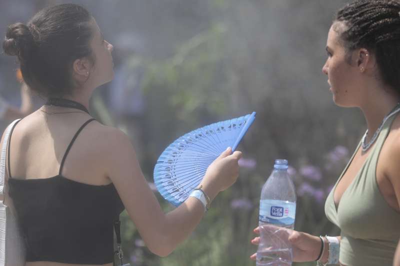 Unas jóvenes se refrescan junto a una fuente de agua pulverizada. EFE/Ana Escobar/Archivo
