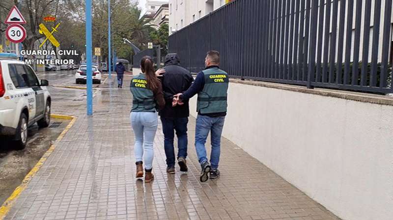 Dos agentes escoltan al detenido, en una imagen compartida por la Guardia Civil. /EFE