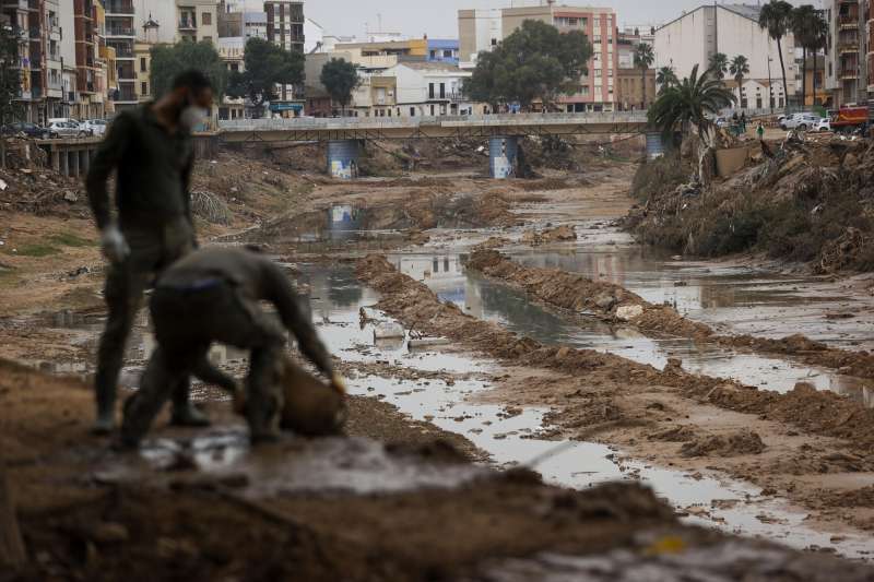 Militares vacan un cubo lleno de lodo en el barranco del Poyo. EFE Manuel Bruque