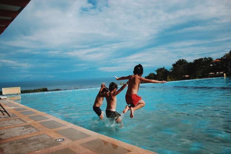 Varios niños saltando en una piscina./EPDA