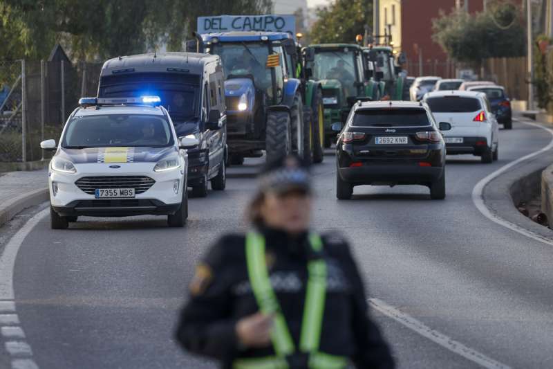 Una columna de tractores circula escoltada por la policía por el camino de Moncada. EFE/Kai Försterling
