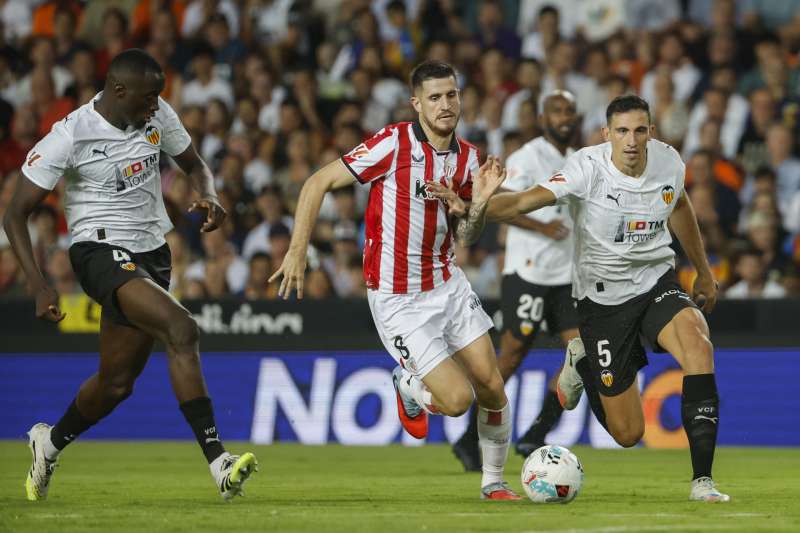 El defensa del Valencia Csar Trrega (d) lucha con Oihan Sancet (c), del Athletic, durante el partido de la quinta jornada de LaLiga que Valencia CF y Athletic de Bilbao disputan este sbado en el estadio de Mestalla. EFEAna Escobar
