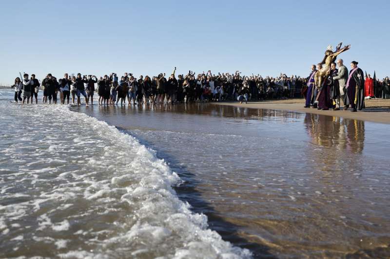 Miembros de la Hemandad del Sant�simo Cristo del Salvador acercan la talla al agua durante la procesi�n del Sant�simo Cristo del Salvador de la Semana Santa Marinera este Viernes Santo en Valencia. EFE Ana Escobar
