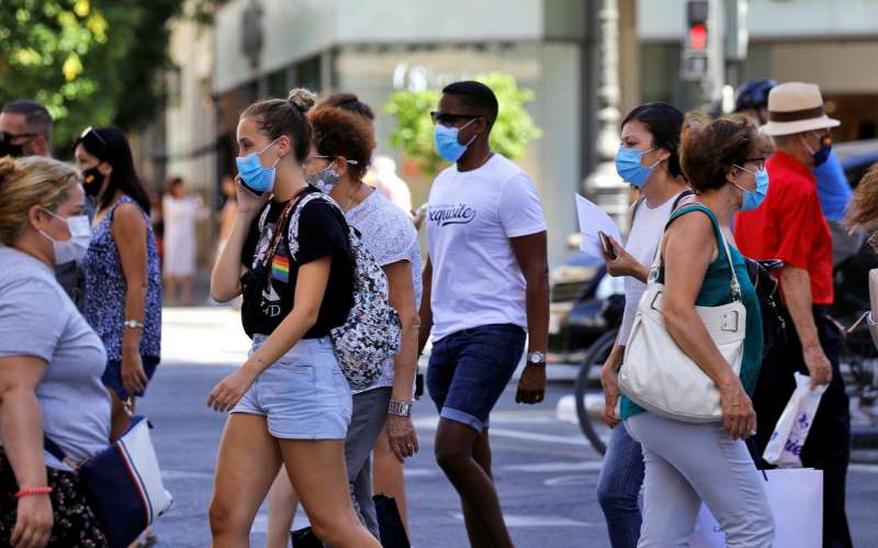 Varias personas cruzan un paso de peatones en una calle de ValÃ¨ncia, con mascarilla en 2021, con algunas restricciones. EFE/Manuel Bruque/Archivo
