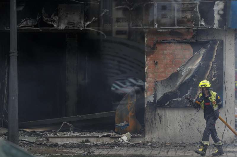 Un bombero trabaja en la extincin del fuego de un comercio situado en un edificio de viviendas de la Avenida del Puerto de Valncia, del que se est procediendo a desalojar a los vecinos y en el que cinco personas han sido atendidas por inhalacin de humo. EFEManuel Bruque
