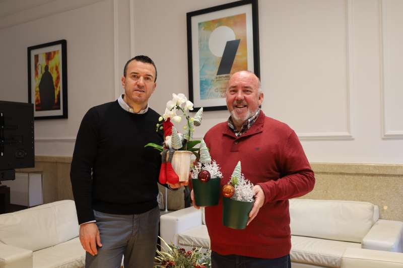 Juan Lluesma otorga unas flores navideas de obsequio a Vicent Momp en el Palau de la Batlia.  EPDA