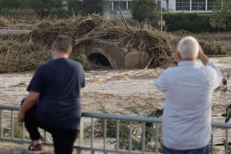 Varios vecinos contemplan un puente arrastrado por el agua en Valencia. EFE Kai Forsterling
