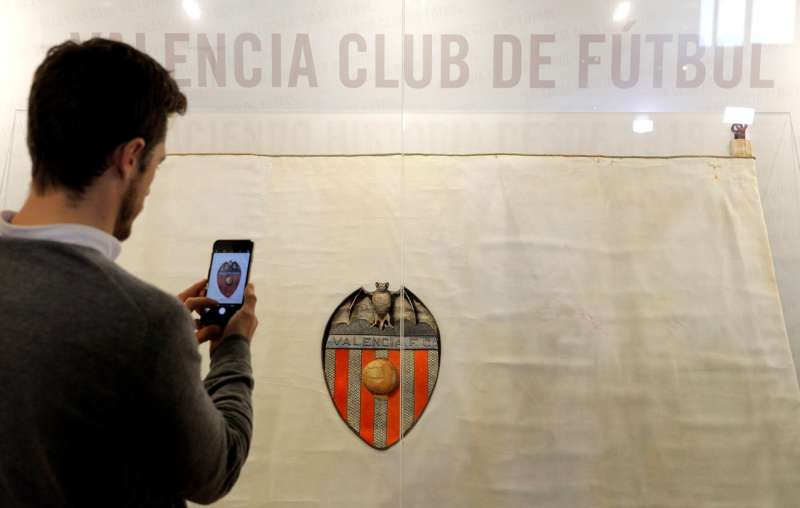 Un aficionado fotografa la primera bandera del Valencia, del 1924. EFE Manuel BruqueArchivo
