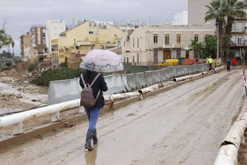 Una mujer cruza el puente de Paiporta, este mircoles. EFEJorge Zapata