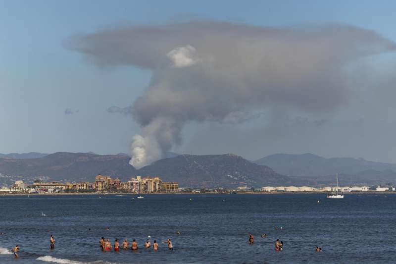 Vista general desde la playa de la Malvarrosa de Valencia, de la columna de humo del incendio declarado en la zona forestal de Puçol (Valencia). EFE/Biel Aliño
