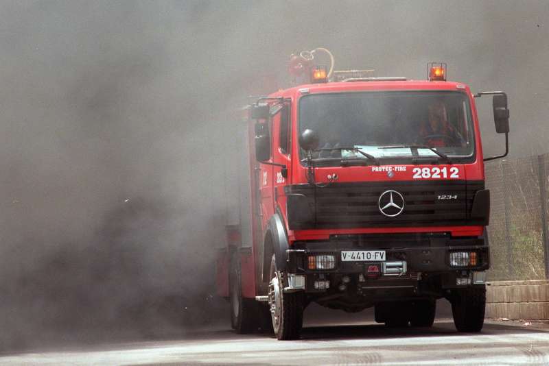 Un camión de bomberos sale de la intensa humareda. Archivo/EFE/J.C.Cardenas.
