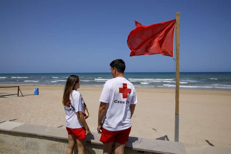 Dos socorristas aguardan en la playa de Guardamar de la Safor, una de playas del sur de la provincia de Valencia afectadas por un posible vertido marino. EFENatxo Francs
