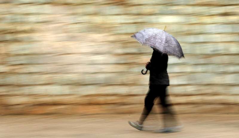 Una persona se protege de la lluvia con paraguas. /EFE