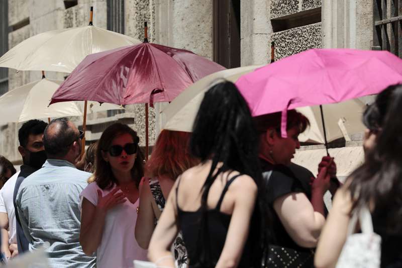 Varias personas se protegen del calor con parasoles./EPDA