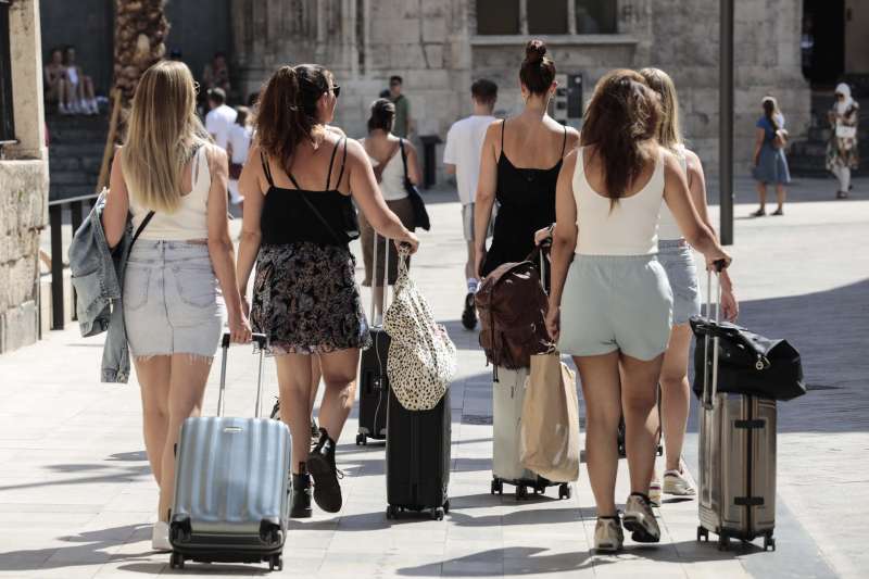 Un grupo de turistas caminan con sus maletas por el centro de Valncia. EFEAna Escobar
