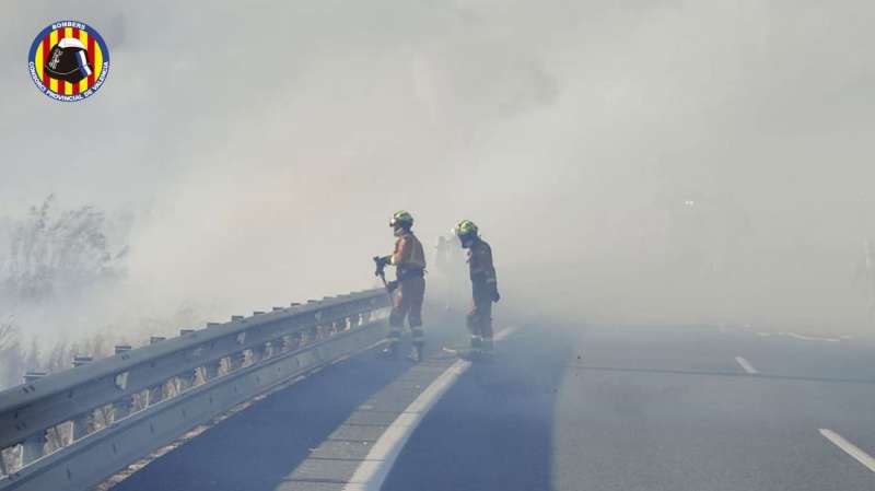 Dos bomberos actúan en un incendio declarado junto a la A-38. EFE/Consorcio Provincial de Bomberos de Valencia.
