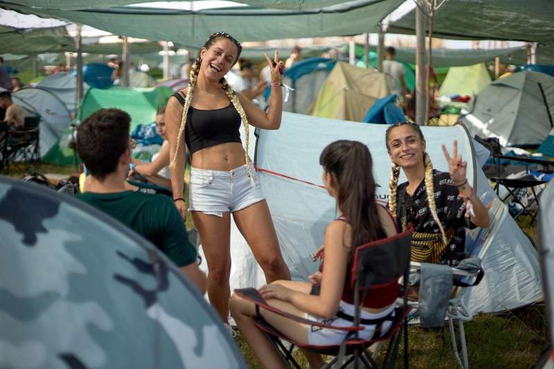 Dos jóvenes saludan tras instalarse en la zona de acampada del Medusa Festival de Cullera (Valencia), en ediciones anteriores. EFE/Natxo Frances/Archivo

