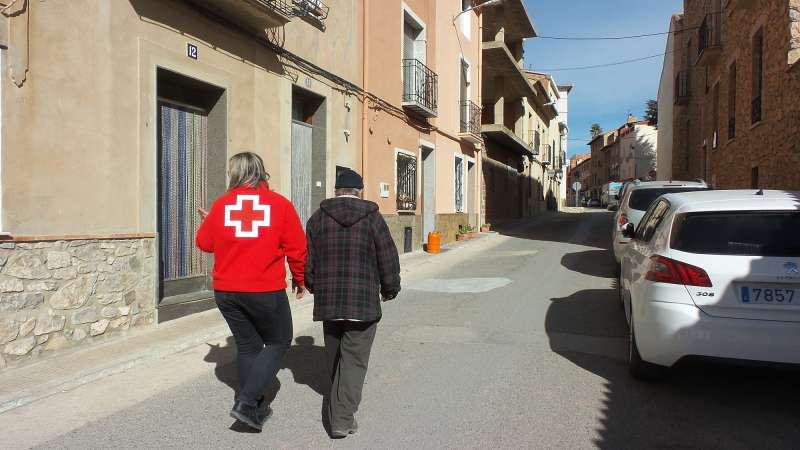 Una voluntaria de Cruz Roja ayuda a una persona mayor. /EPDA