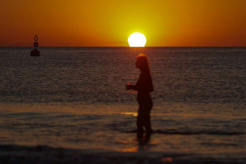 Una joven pasea dentro del mar mientras amanece, en la playa de La Malvarrosa de ValÃ¨ncia. EFE/Manuel Bruque/ARchivo
